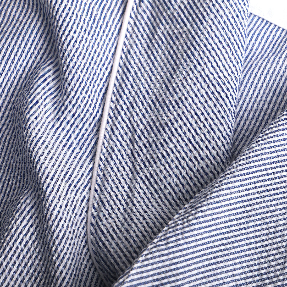 Soft and light and oh-so-right. Our seersucker robe is perfect for those lazy days around the house. Looks stunning while scratching absolutely nothing off of your honey-do list.  Unlined  •  Machine Washable  •  100% Cotton Seersucker  •  Left Chest Pocket  •  Two Patch Pockets  •  Inner Tie  •  Outer Belt Tie with Loops  •  Navy & White Seersucker  •  One Size Fits All  •  Imported