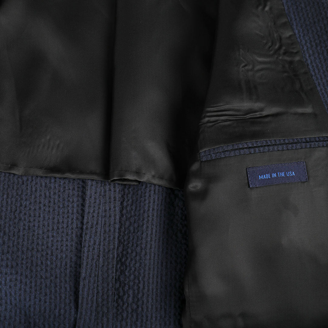A nod to one of our favorite New Orleans cocktails, spiced with the warmth of cognac. Navy spiced up with the worlds best seersucker pucker. Always cool.   97% Cotton / 3% Lycra Haspel Exclusive Seersucker Stretch Fabric  •  Maximized Seersucker Pucker  •  Audubon Classic Fit  •  Natural Shoulder  •  Two Buttons  •  Flap Pockets  •  3/4 Lined for Maximum Cool  •  Side Vents  •  Notch Lapel  •  Dry Clean  •  Made in USA